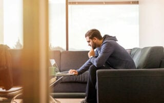 Pornos. Mann im Wohnzimmer vor seinem Laptop