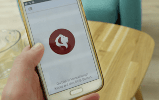 SOS-Button. Smartphone auf dem SOS-Button der App aufscheint.