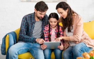 Elternaktion. Familie sitzt auf gelbem Sofa