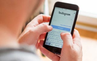 Instagram. Hände halten Smartphone