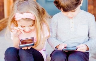 Volksschulalter. Zwei Kinder mit Smartphones