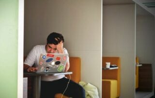 Teenageralter. Junger Mann sitzt am Laptop