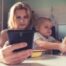 Suchtpotential. Mutter mit Kindern und Smartphone